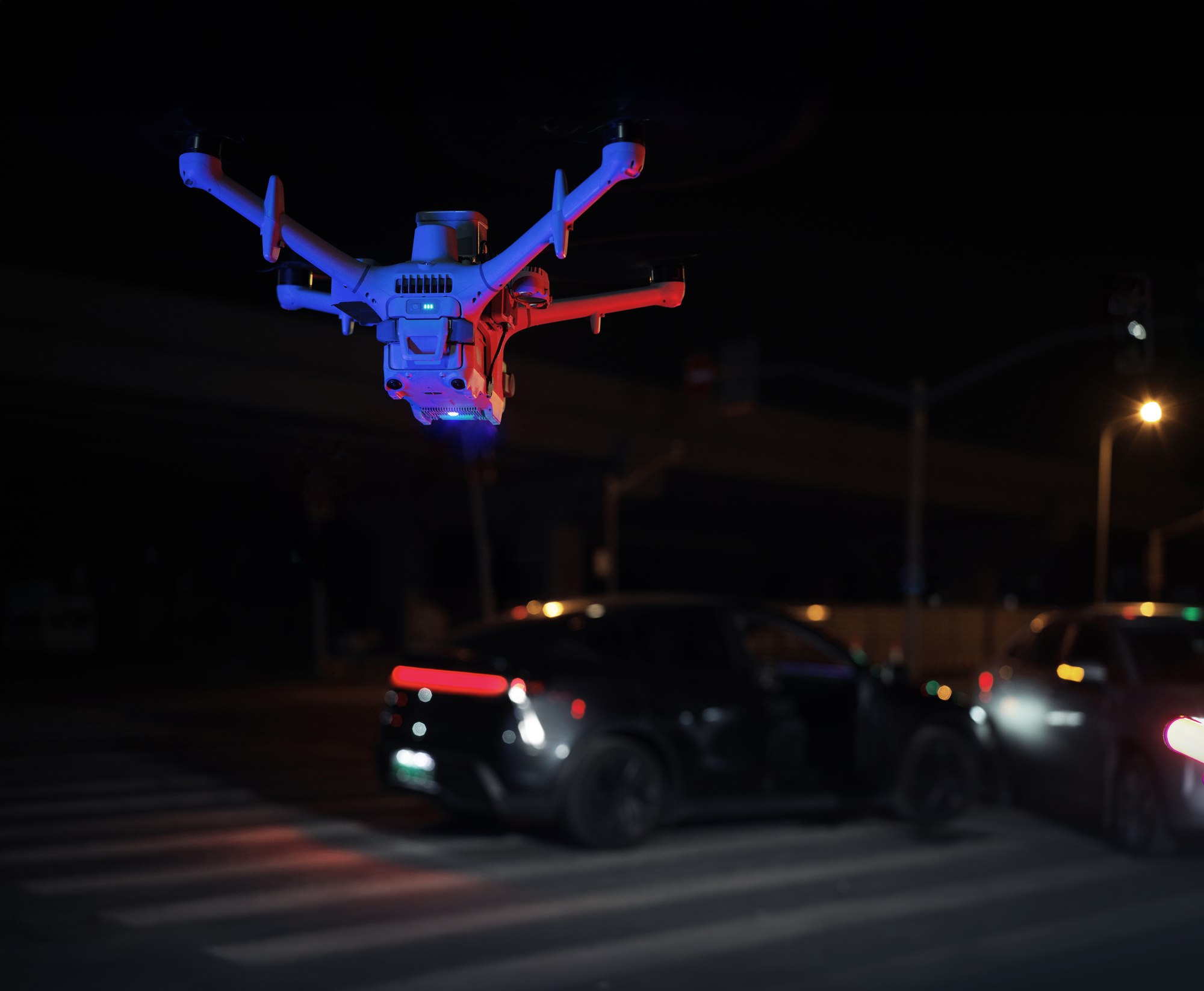 DJI Matrice 5TD mit roten und blauen Signallichtern, Lautsprecher und Scheinwerfer über einer Straße